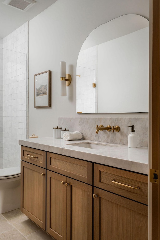 full bath featuring visible vents, tasteful backsplash, a tile shower, vanity, and toilet