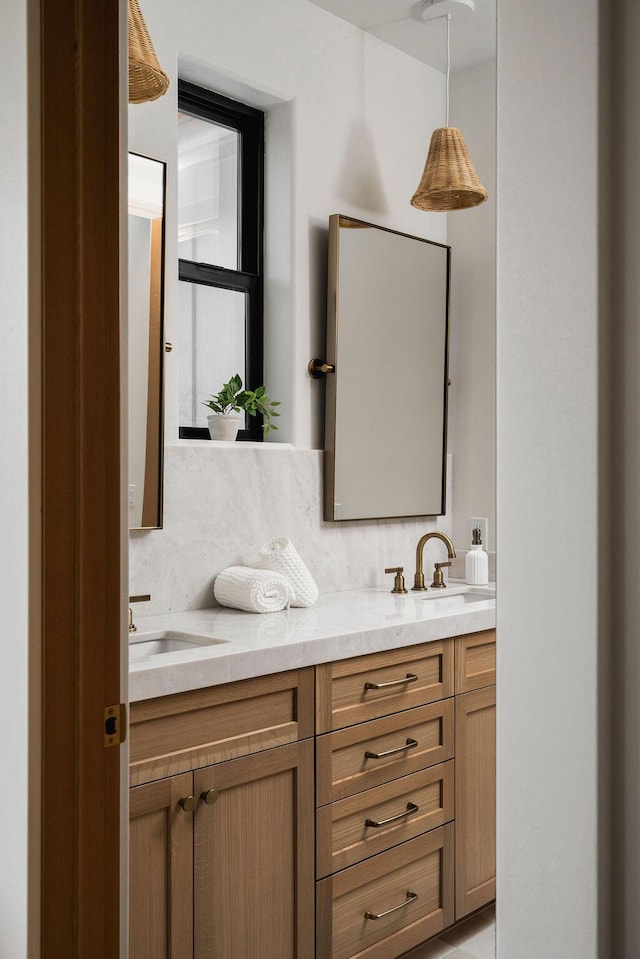 bathroom with double vanity, a sink, and tasteful backsplash