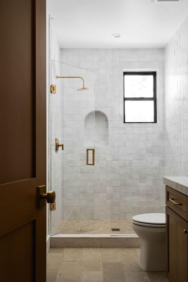full bath with vanity, a shower stall, and toilet