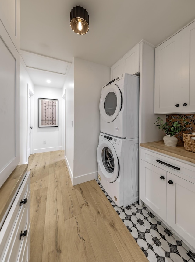 23 Calaveras Ave, Goleta, CA 93117 - laundry room featuring recessed lighting, stacked washer / dryer, baseboards, light wood-type flooring, and cabinet space