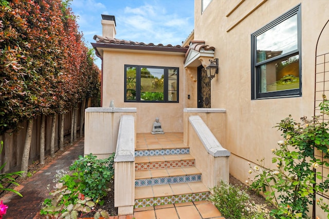305 E Islay St, Santa Barbara, CA 93101 - doorway to property featuring stucco siding, a chimney, and fence