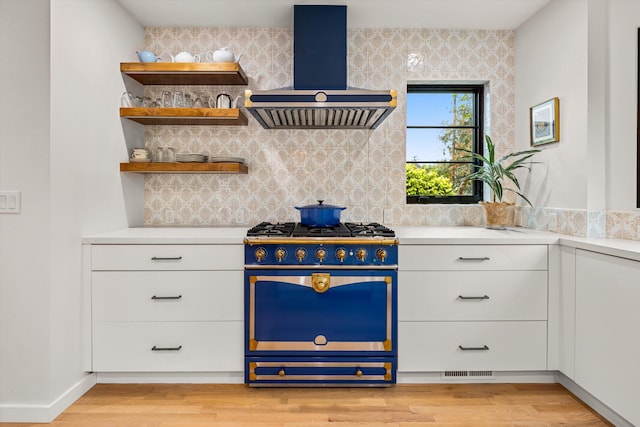 305 E Islay St, Santa Barbara, CA 93101 - kitchen with exhaust hood, high end stainless steel range oven, light countertops, backsplash, and white cabinets