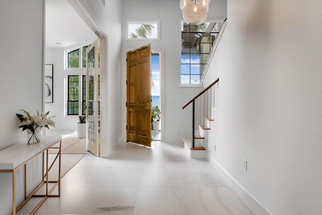 904 E Fir Ave, Lompoc, CA 93436 - foyer entrance featuring stairway, a high ceiling, baseboards, and a chandelier