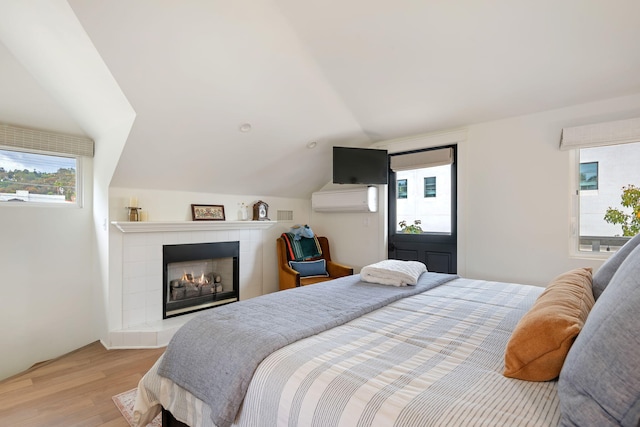 910 N Nopal St, Santa Barbara, CA 93103 - bedroom with wood finished floors, a wall mounted AC, vaulted ceiling, and a tiled fireplace