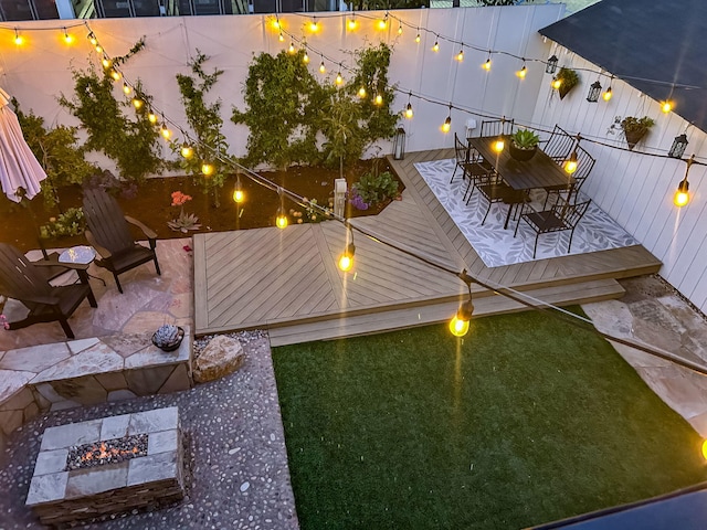 910 N Nopal St, Santa Barbara, CA 93103 - yard at night with a fire pit, a wooden deck, and outdoor dining space