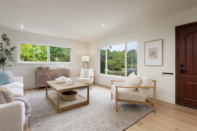 living room featuring light wood finished floors, baseboards, and recessed lighting