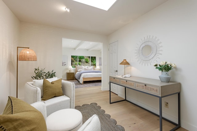bedroom with light wood finished floors, beam ceiling, and recessed lighting