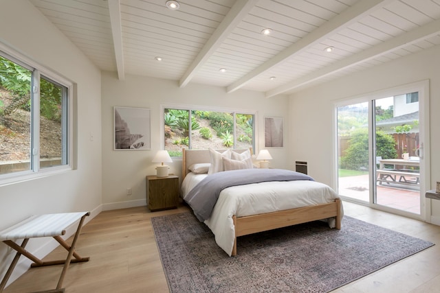 bedroom with multiple windows, access to outside, beam ceiling, light wood-style flooring, and baseboards