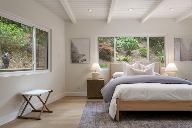 bedroom with multiple windows, light wood-style floors, beamed ceiling, baseboards, and recessed lighting