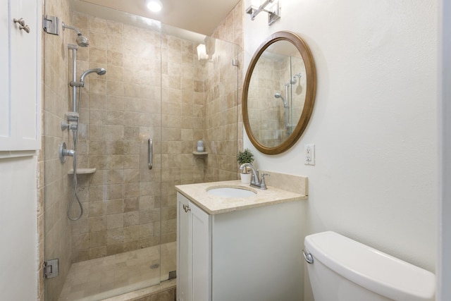 full bathroom featuring a shower stall, toilet, and vanity
