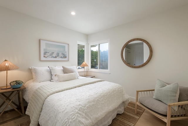 bedroom with baseboards, wood finished floors, and recessed lighting