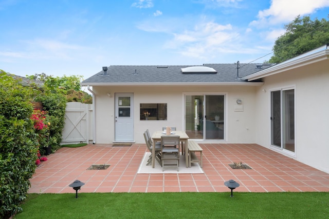 back of property featuring stucco siding, a patio, a gate, and roof with shingles