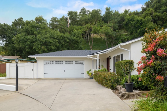 ranch-style house with an attached garage, stucco siding, and driveway