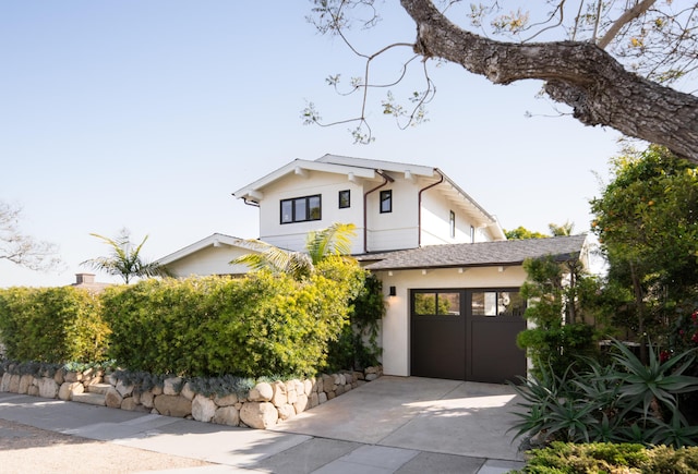 view of front of home featuring concrete driveway, stucco siding, and a garage