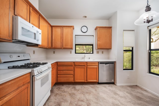 4643 Gerona Way, Santa Barbara, CA 93110 - kitchen with white appliances, a sink, light countertops, hanging light fixtures, and brown cabinetry