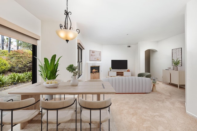 4643 Gerona Way, Santa Barbara, CA 93110 - carpeted dining area with a lit fireplace and arched walkways