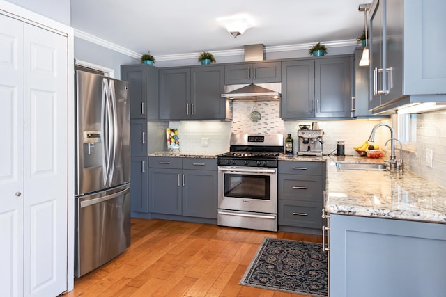 3933 Foothill Rd, Santa Barbara, CA 93110 - kitchen featuring appliances with stainless steel finishes, a sink, under cabinet range hood, light stone counters, and light wood-type flooring