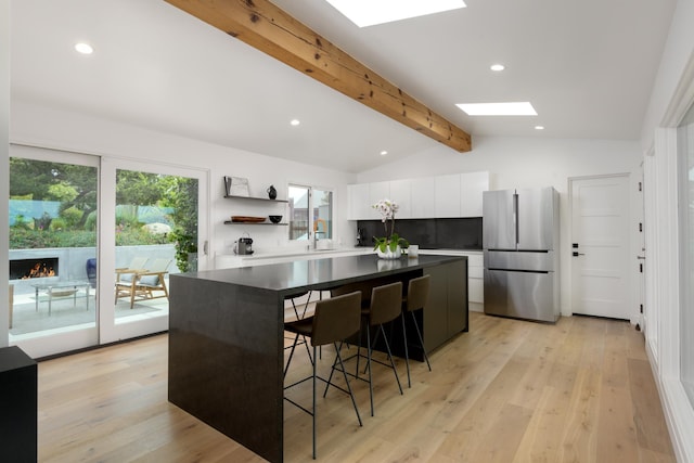 415 Yankee Farm Rd, Santa Barbara, CA 93109 - kitchen featuring freestanding refrigerator, open shelves, white cabinets, a sink, and a center island