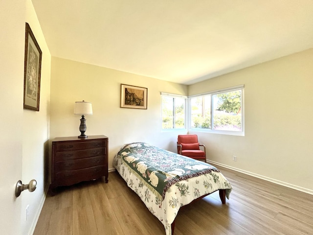 bedroom featuring wood finished floors and baseboards