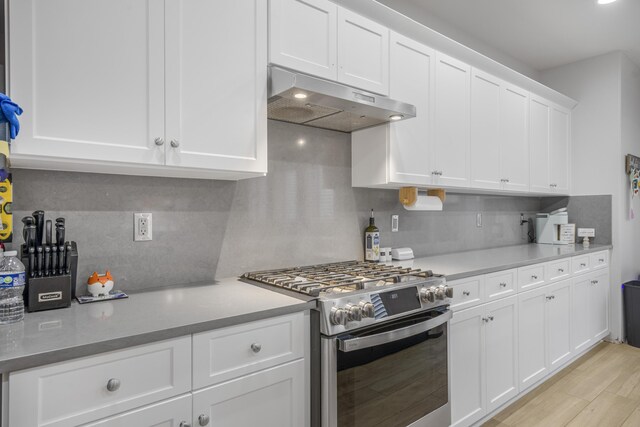 1010 Tranquillion Ct, Lompoc, CA 93436 - kitchen with stainless steel gas range, under cabinet range hood, tasteful backsplash, white cabinetry, and light wood finished floors