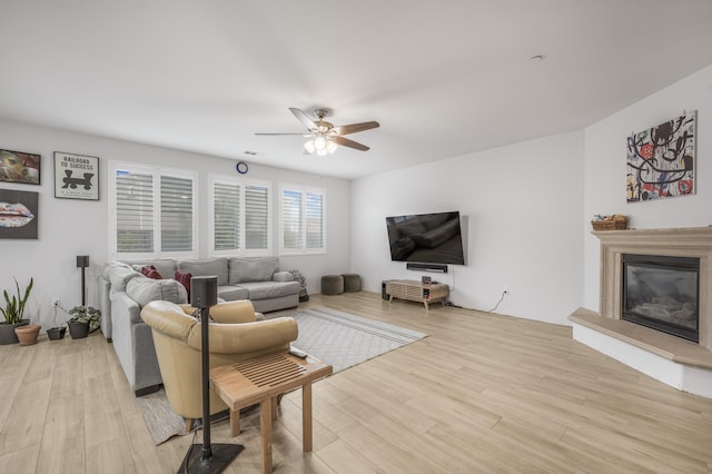1010 Tranquillion Ct, Lompoc, CA 93436 - living area featuring light wood finished floors, a glass covered fireplace, and ceiling fan