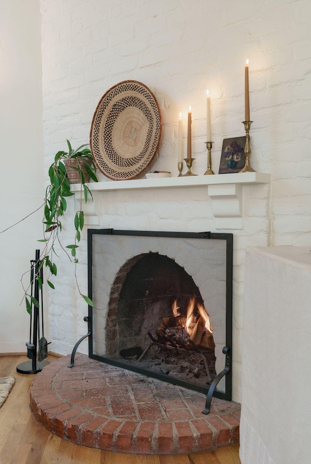 detailed view of a brick fireplace and wood finished floors
