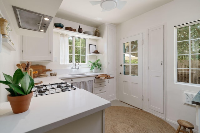 kitchen featuring a sink, light countertops, white cabinets, a ceiling fan, and open shelves