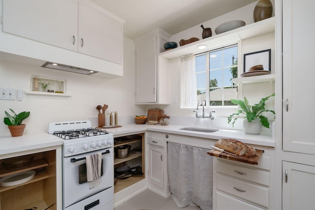 kitchen with gas range gas stove, open shelves, a sink, white cabinets, and light countertops
