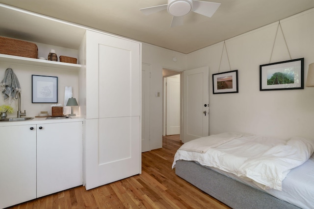 bedroom with a sink, light wood-style flooring, and ceiling fan