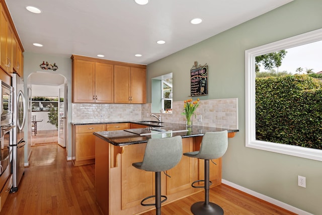 170 Loma Media Rd, Santa Barbara, CA 93103 - kitchen featuring a peninsula, light wood-style flooring, backsplash, recessed lighting, and a breakfast bar area