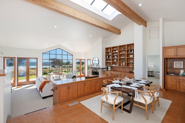 5529 Calle Arena, Carpinteria, CA 93013 - kitchen with a fireplace, a peninsula, light tile patterned flooring, beam ceiling, and a sink