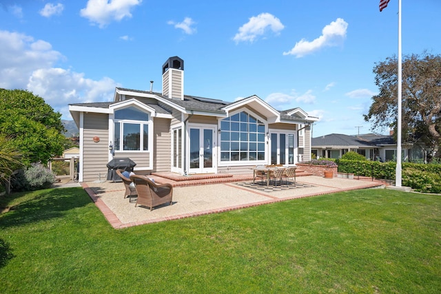 5529 Calle Arena, Carpinteria, CA 93013 - rear view of property featuring french doors, a lawn, a patio, and a chimney