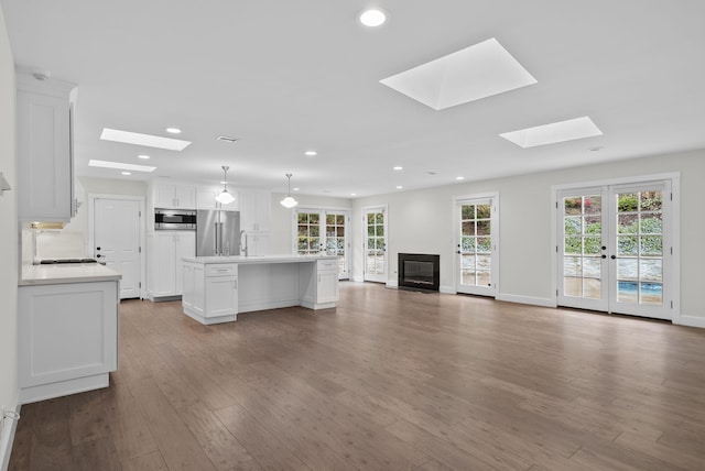919 Aleeda Ln, Santa Barbara, CA 93108 - unfurnished living room featuring a skylight, recessed lighting, wood finished floors, plenty of natural light, and a sink