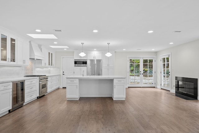 919 Aleeda Ln, Santa Barbara, CA 93108 - kitchen with custom range hood, premium appliances, beverage cooler, hardwood / wood-style flooring, and recessed lighting