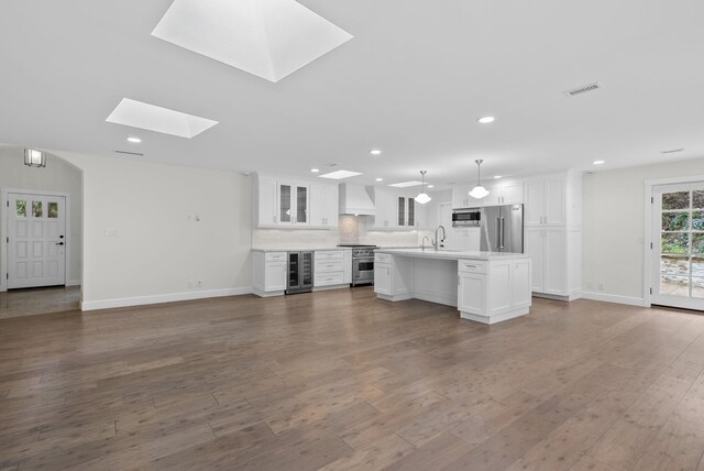 919 Aleeda Ln, Santa Barbara, CA 93108 - unfurnished living room with a skylight, beverage cooler, a sink, wood finished floors, and recessed lighting