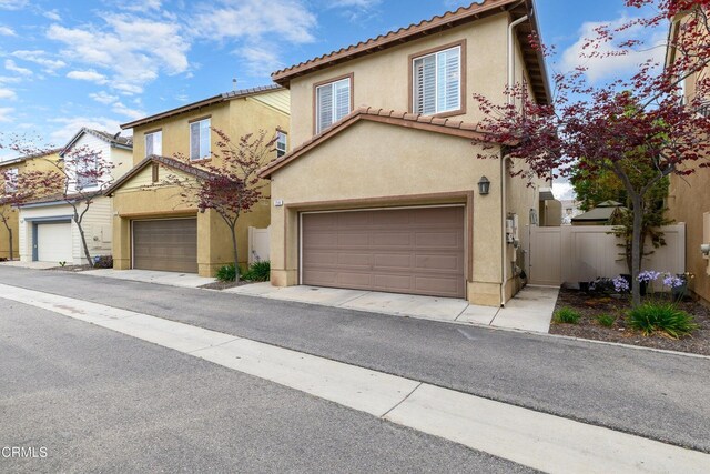 714 Nile River Dr, Oxnard, CA 93036 - view of front of home featuring stucco siding, fence, an attached garage, and a tiled roof