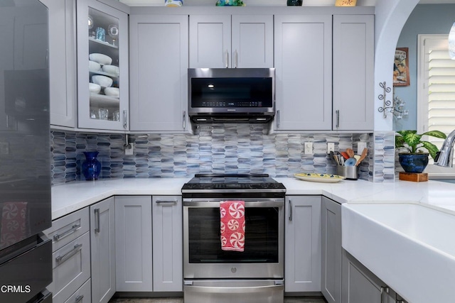 714 Nile River Dr, Oxnard, CA 93036 - kitchen featuring stainless steel appliances, a sink, light countertops, decorative backsplash, and gray cabinets