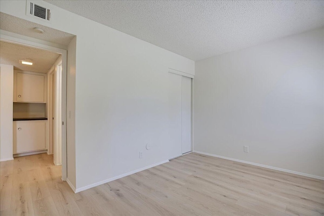232 Rosewood St, Ventura, CA 93001 - unfurnished room with light wood-type flooring, a textured ceiling, baseboards, and a smoke detector