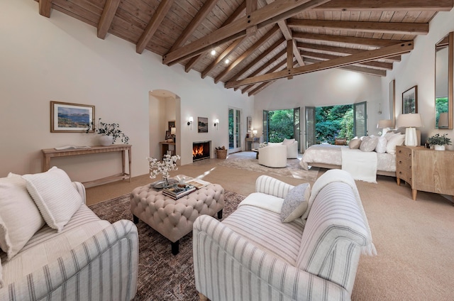 603 Juan Crespi Ln, Montecito, CA 93108 - living room with wood ceiling with exposed beams, high vaulted ceiling, carpet flooring, a lit fireplace, and arched walkways