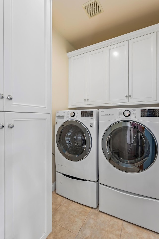 5049 Via Lara Ln, Santa Barbara, CA 93111 - laundry room with cabinet space, washing machine and dryer, and light tile patterned floors