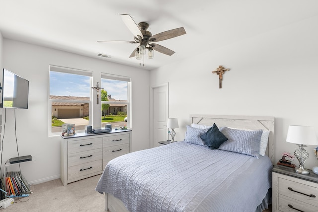 bedroom featuring light carpet, a ceiling fan, and baseboards