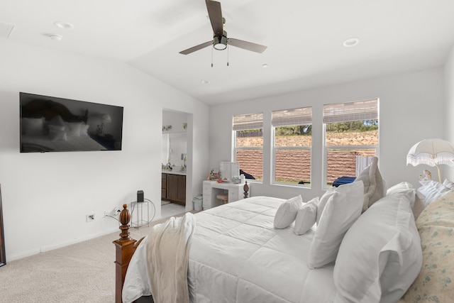 bedroom with vaulted ceiling, multiple windows, light colored carpet, baseboards, and ceiling fan