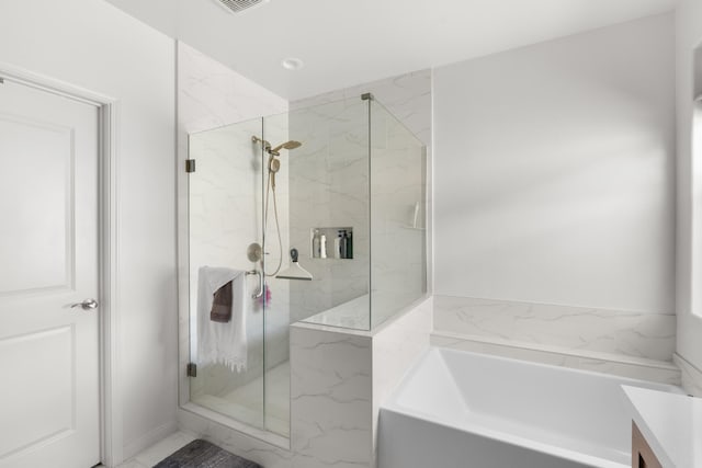 bathroom with a marble finish shower and a garden tub