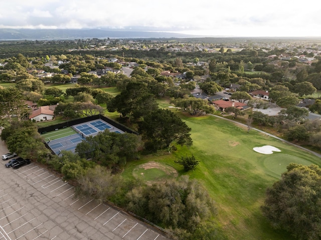 aerial view of property and surrounding area featuring a local golf course and nearby suburban area