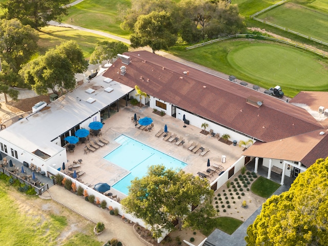 drone / aerial view of a pool area and a local golf course
