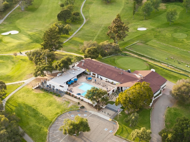 view of property location with a pool and a golf club