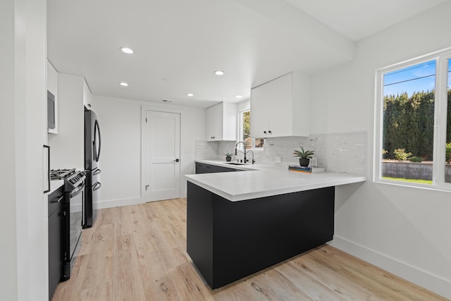 246 3rd St, Solvang, CA 93463 - kitchen featuring black gas range, a sink, light countertops, baseboards, and a peninsula