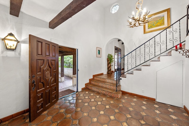 725 Ashley Rd, Montecito, CA 93108 - foyer entrance featuring arched walkways, beamed ceiling, a chandelier, stairway, and high vaulted ceiling