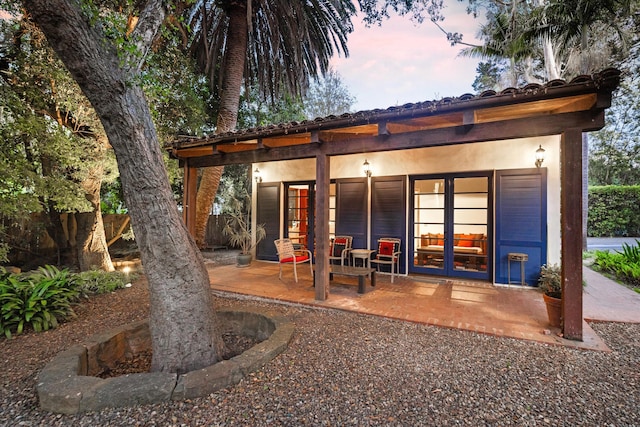 725 Ashley Rd, Montecito, CA 93108 - back of property at dusk featuring french doors and stucco siding