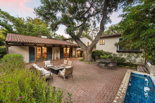 725 Ashley Rd, Montecito, CA 93108 - back of property featuring stucco siding, a patio area, a tile roof, an outdoor living space with a fire pit, and an outdoor pool